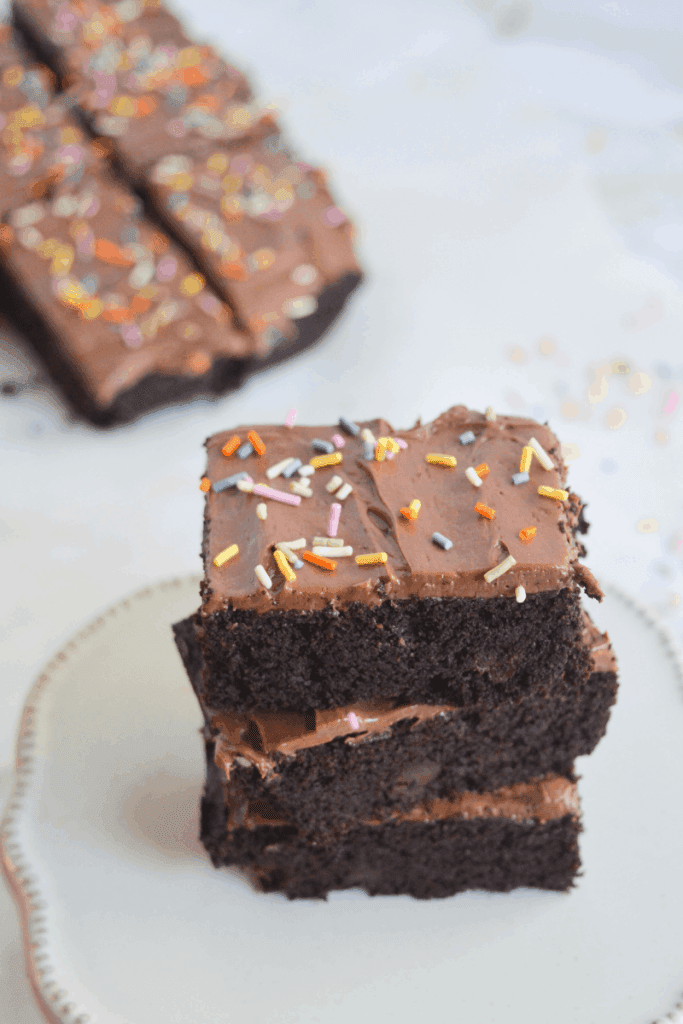 stack of keto brownies covered in sprinkles on a white plate