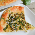 two slices of keto spinach pesto flatbread on a white plate