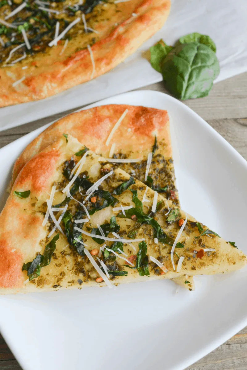 two slices of keto spinach pesto flatbread on a white plate