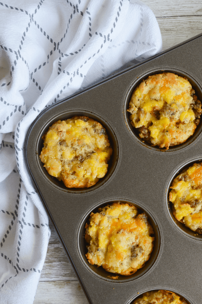 four keto breakfast bombs in the muffin tin after cooking, resting on a white towel