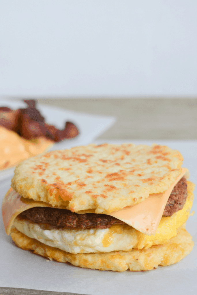 egg, sausage patty, and cheese sandwiched between two cauliflower buns