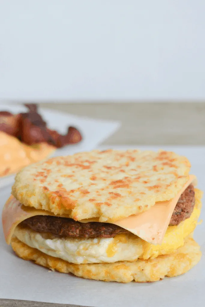 egg, sausage patty, and cheese sandwiched between two cauliflower buns