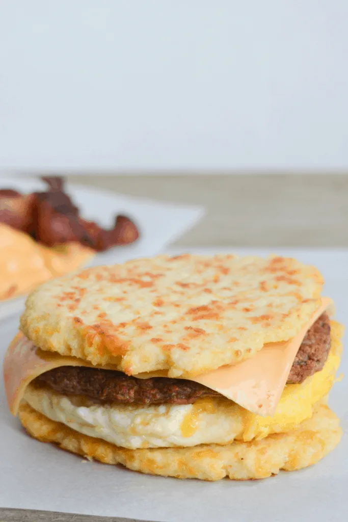 egg, sausage patty, and cheese sandwiched between two cauliflower buns