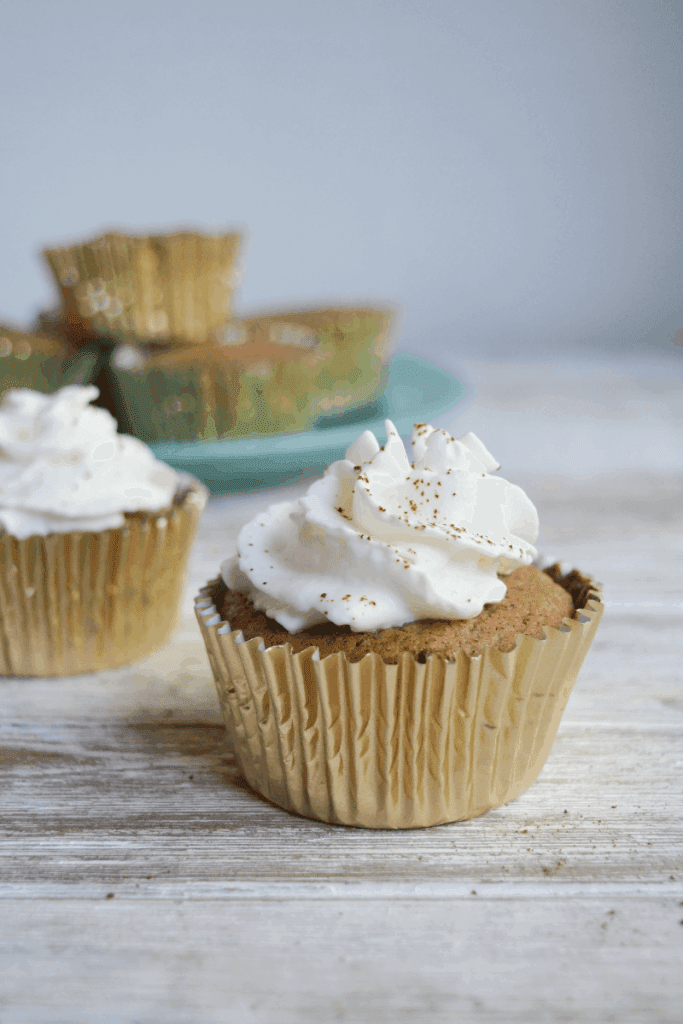 One Muffin in the foreground topped with whipped cream and espresso powder