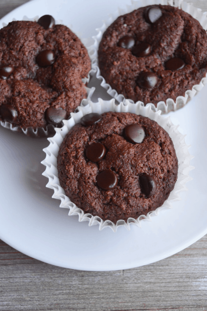three double chocolate muffins sitting on a white plate