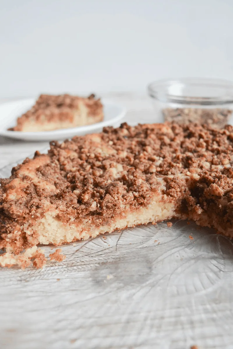 coffee cake sitting on a decorative glass plate, cut to show moist inside texture