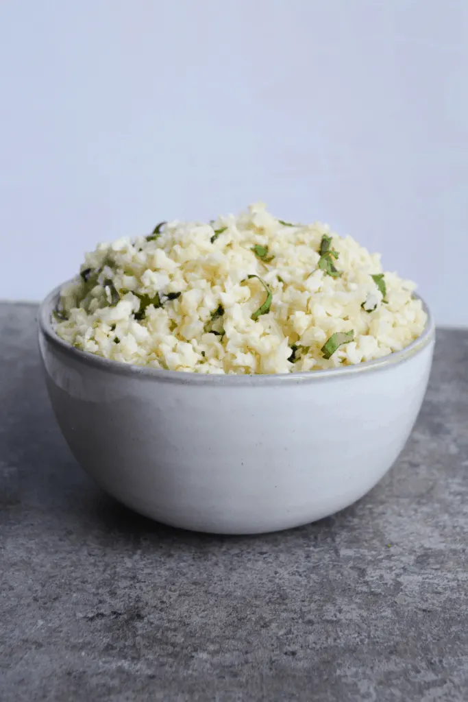 bowl of cauliflower rice sitting on a gray board