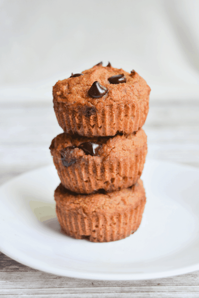 three keto pumpkin muffins stacked on a white plate