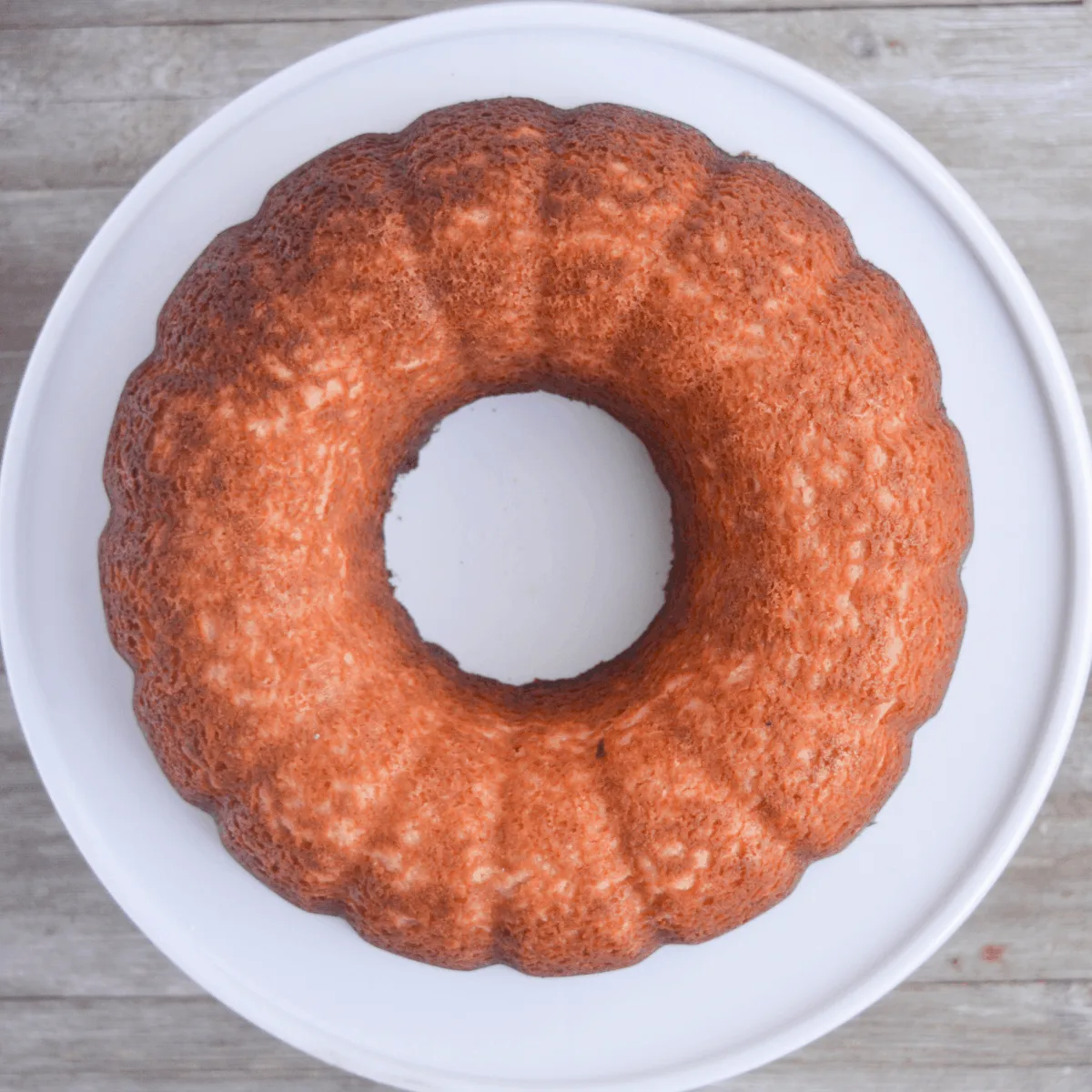 full unglazed keto lemon pound cake sitting on a white cake tray