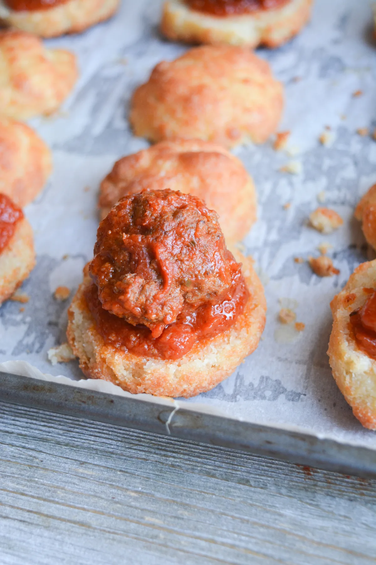 garlic bread meatball sliders mid-construction on a baking sheet