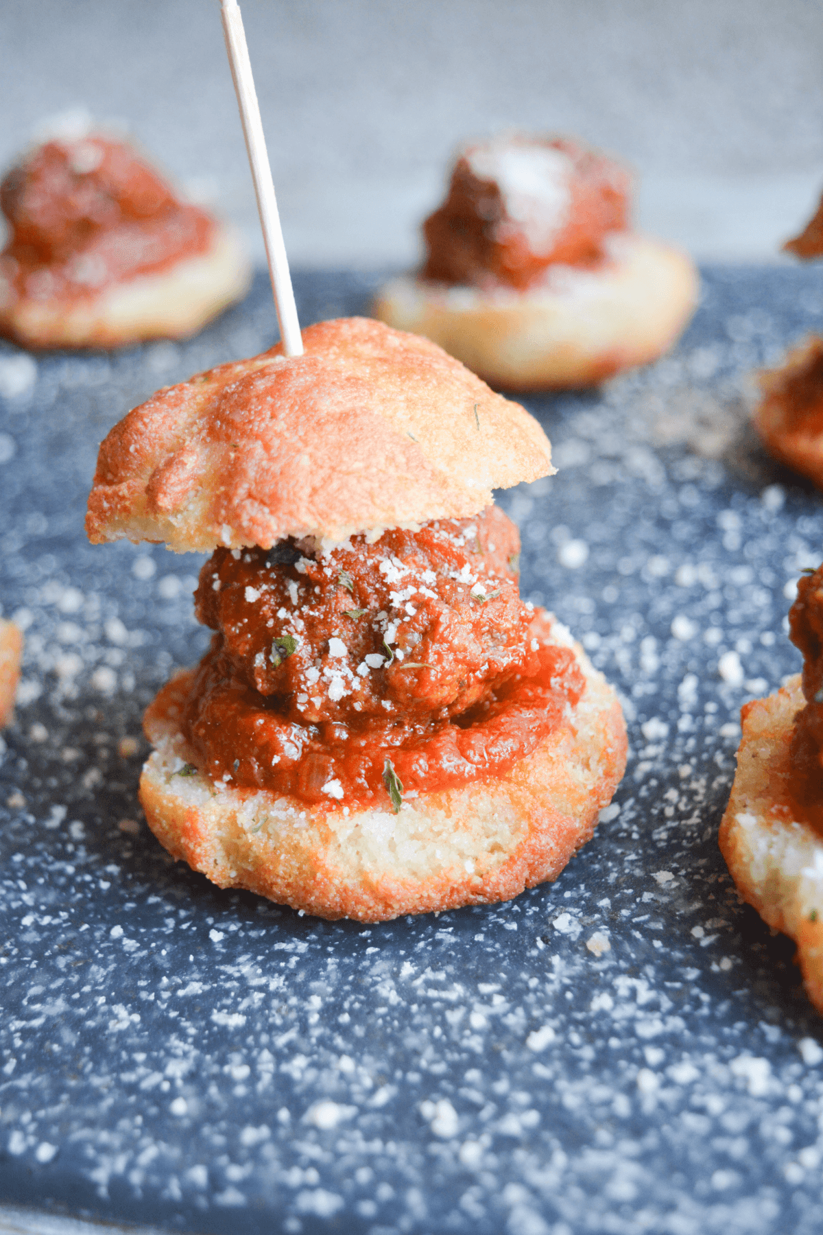 close up of one keto garlic bread meatball slider with a toothpick in it