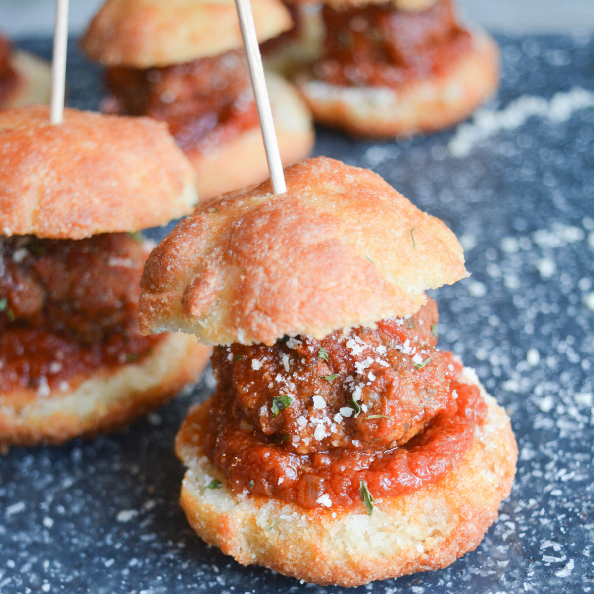 close up of one keto garlic bread meatball slider with a toothpick in it