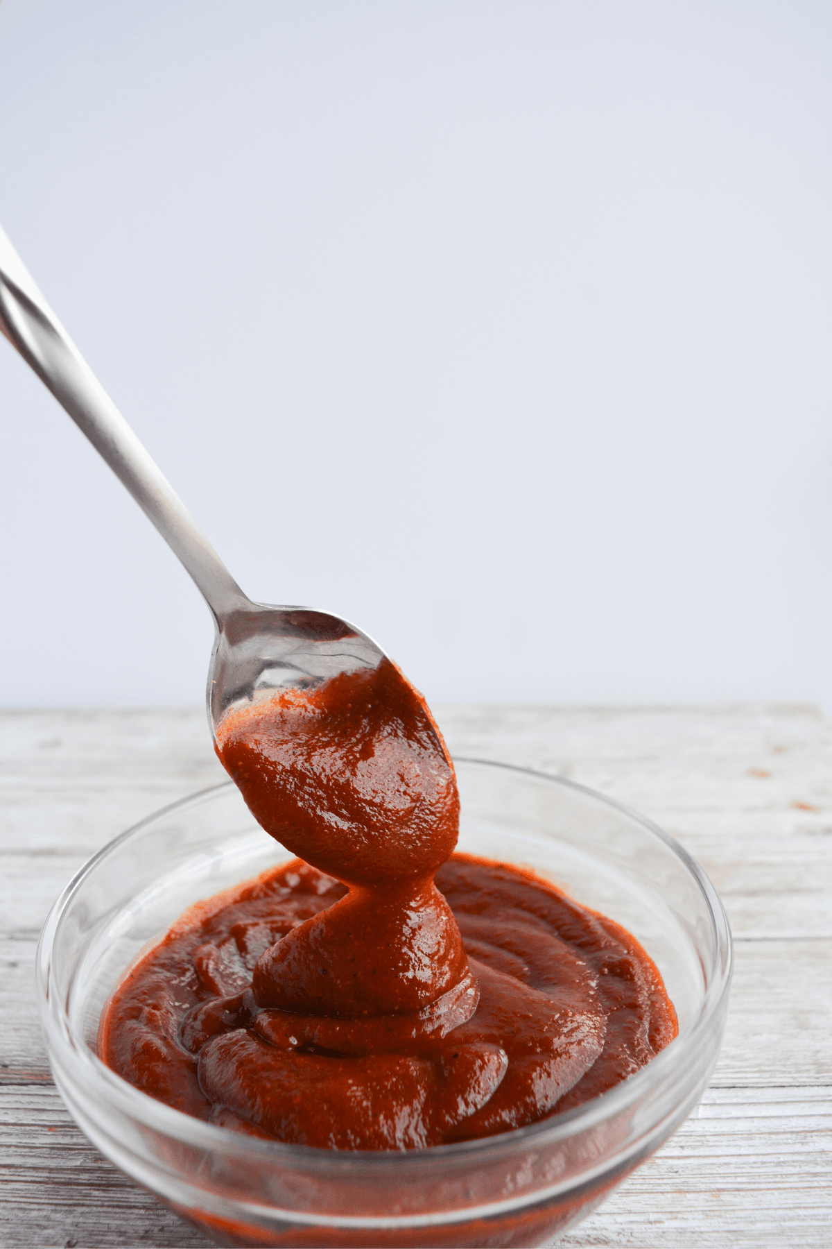 bowl of keto bbq sauce with a spoon scooping some out