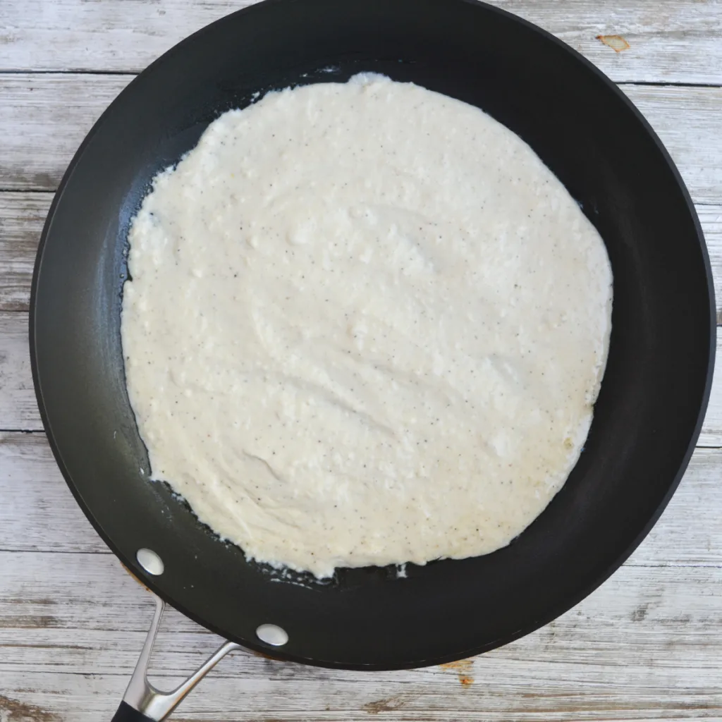 fluffy parmesan scrambled eggs step one: adding the cream cheese, butter, heavy whipping cream, grated parmesan and black pepper to a saucepan to simmer