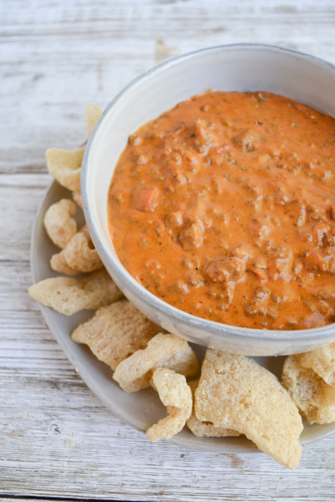 bowl of keo chili cheese dip with pork rinds on the side for dipping