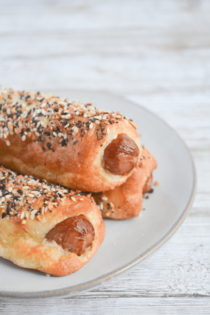 close up on three keto pigs in a blanket on a white plate