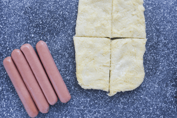 keto pigs in a blanket step 2 - cutting the dough to wrap around the hot dogs