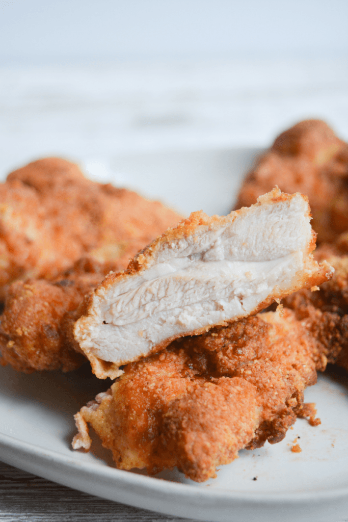 crispy low carb air fryer keto fried chicken, cut open to show juicy and delicious inside