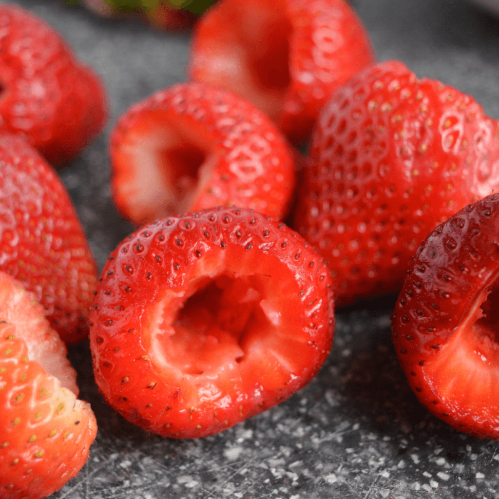 keto cheesecake stuffed strawberries - step two - cutting the tops off of the strawberries and scooping out the insides