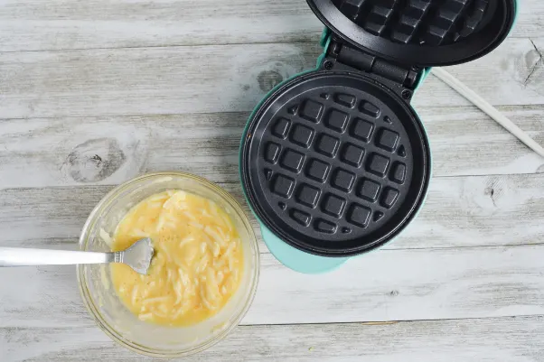 chaffles mixture sitting next to a preheated waffle iron