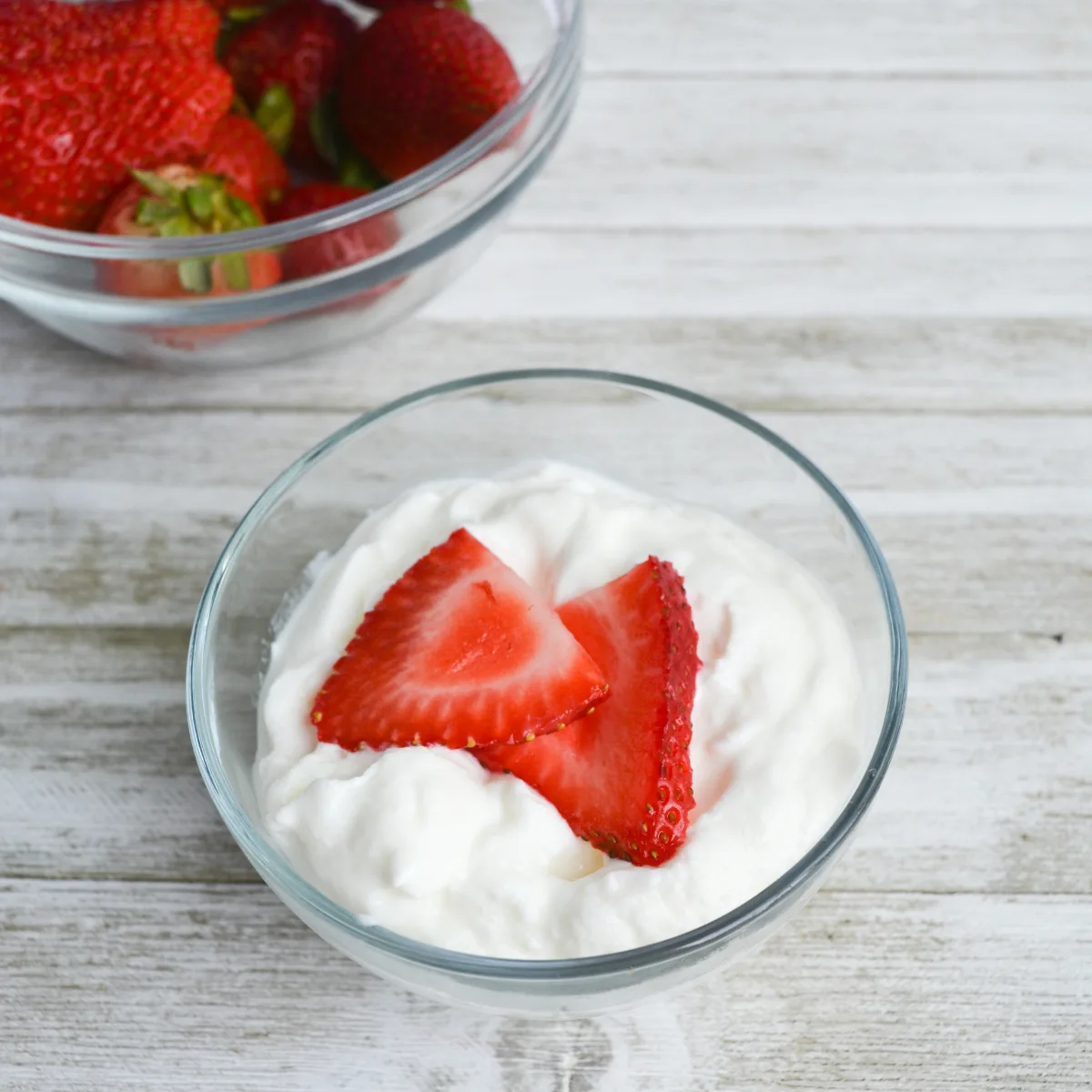 serving of keto yogurt in a bowl, topped with sliced strawberries