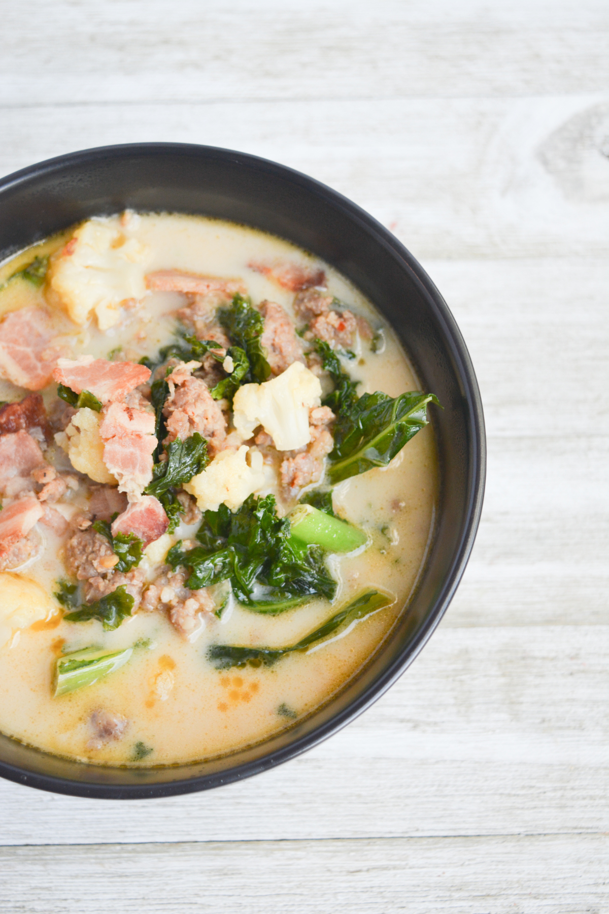 black bowl of cooked keto zuppa toscana soup.