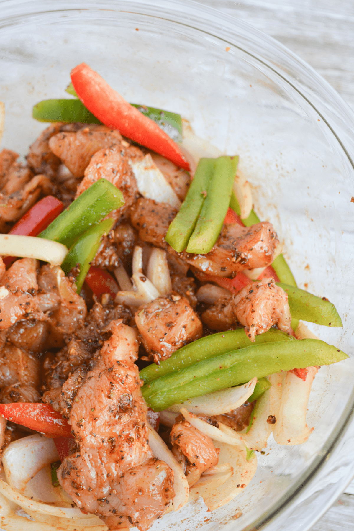 chicken fajitas ingredients mixed in bowl.